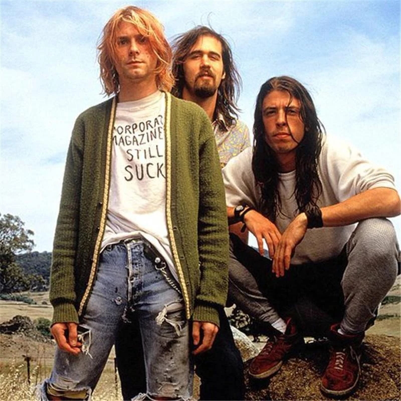 Nirvana en 1993, Cobain con un cardigan verde y una polera que dice "Corporate Magazines Still Suck", junto a Novoselic y Grohl